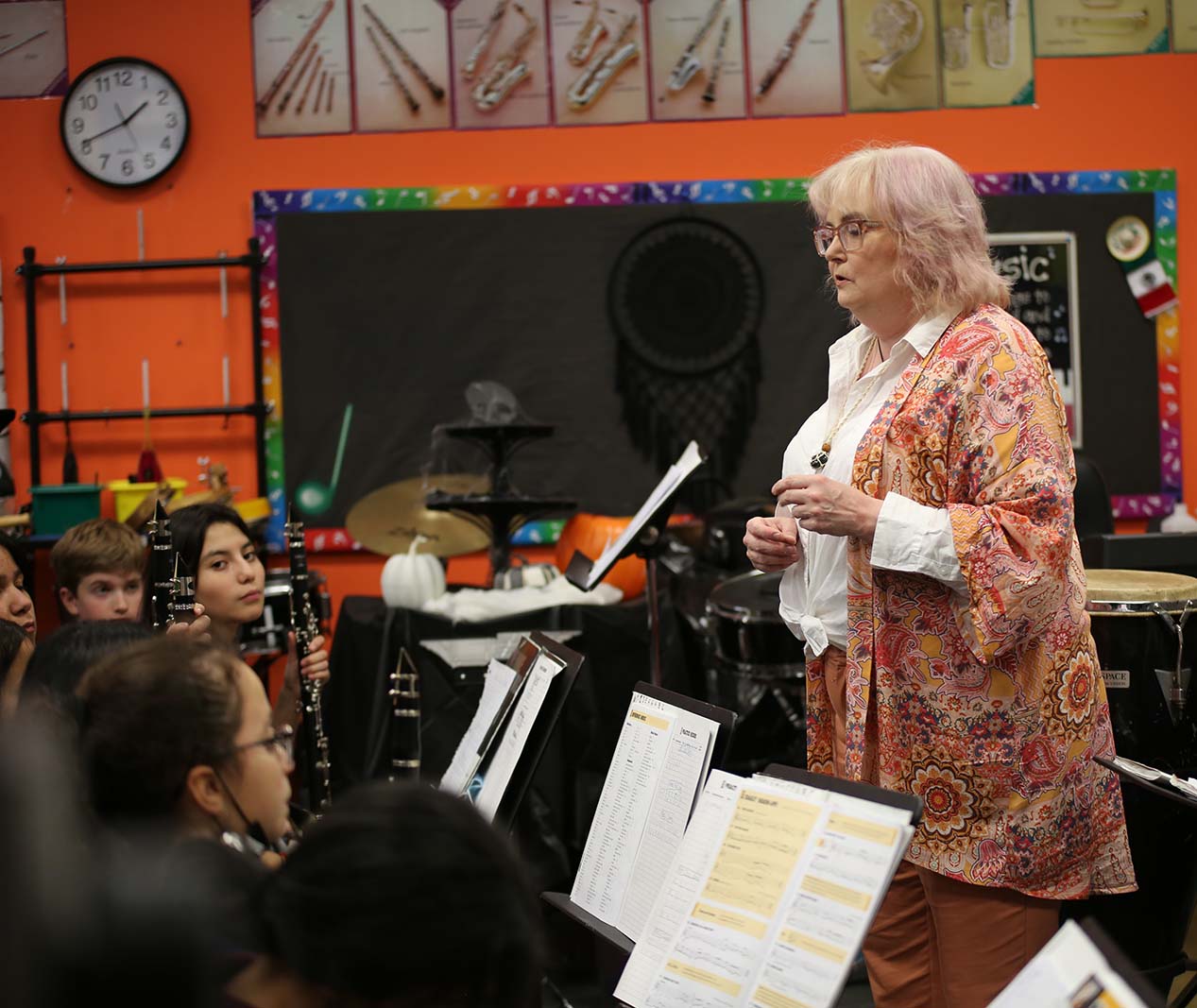 HSA Teacher smiles while kneeling beside a young student in a classroom setting.